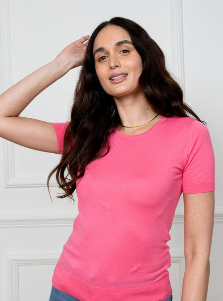 Woman wearing flamingo pink short sleeved knit top in premium and luxury sea island cotton.